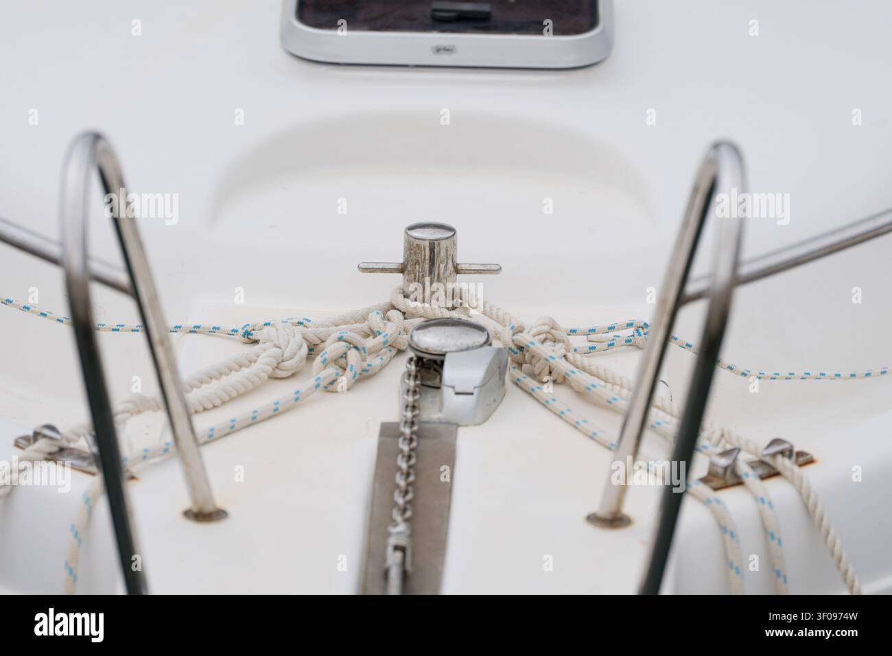 Close-up d'une clé de pont de voilier avec une corde nouée et des accessoires en acier inoxydable, concept de détail d'équipement de navigation nautique. Banque D'Images