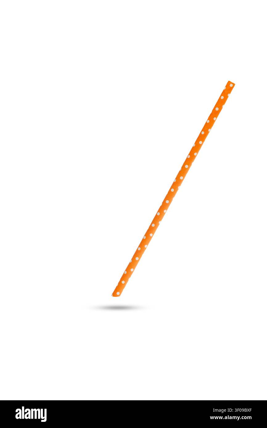 Une paille orange à pois blancs flottant sur un fond blanc Banque D'Images