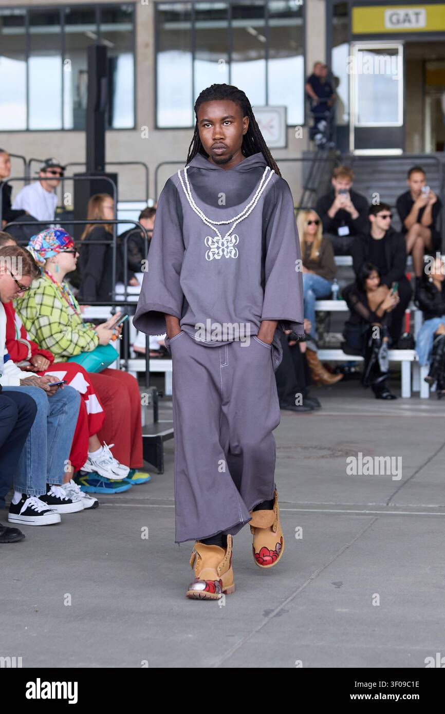 Berlin, Allemagne, 4 juil., 2026. Le mannequin porte un sweat à capuche gris et un short large de sample030 lors de la Berlin Fashion Week SS27 à l'aéroport de Tempelhof. Banque D'Images