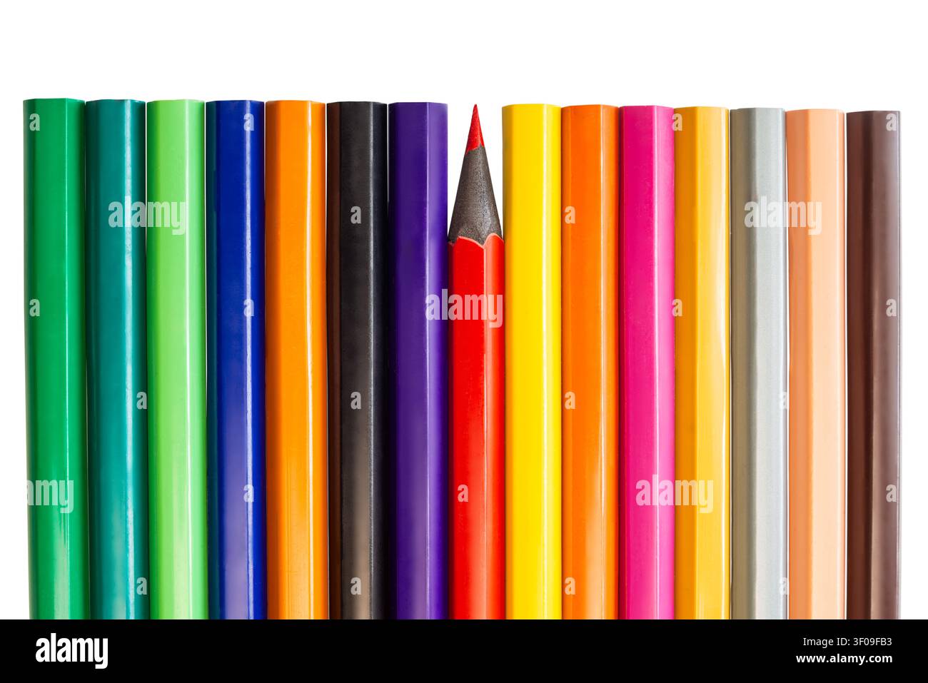 De nombreux crayons de couleur sont alignés en rangée, un crayon rouge se distinguant des autres. Les crayons présentent différentes couleurs. Banque D'Images