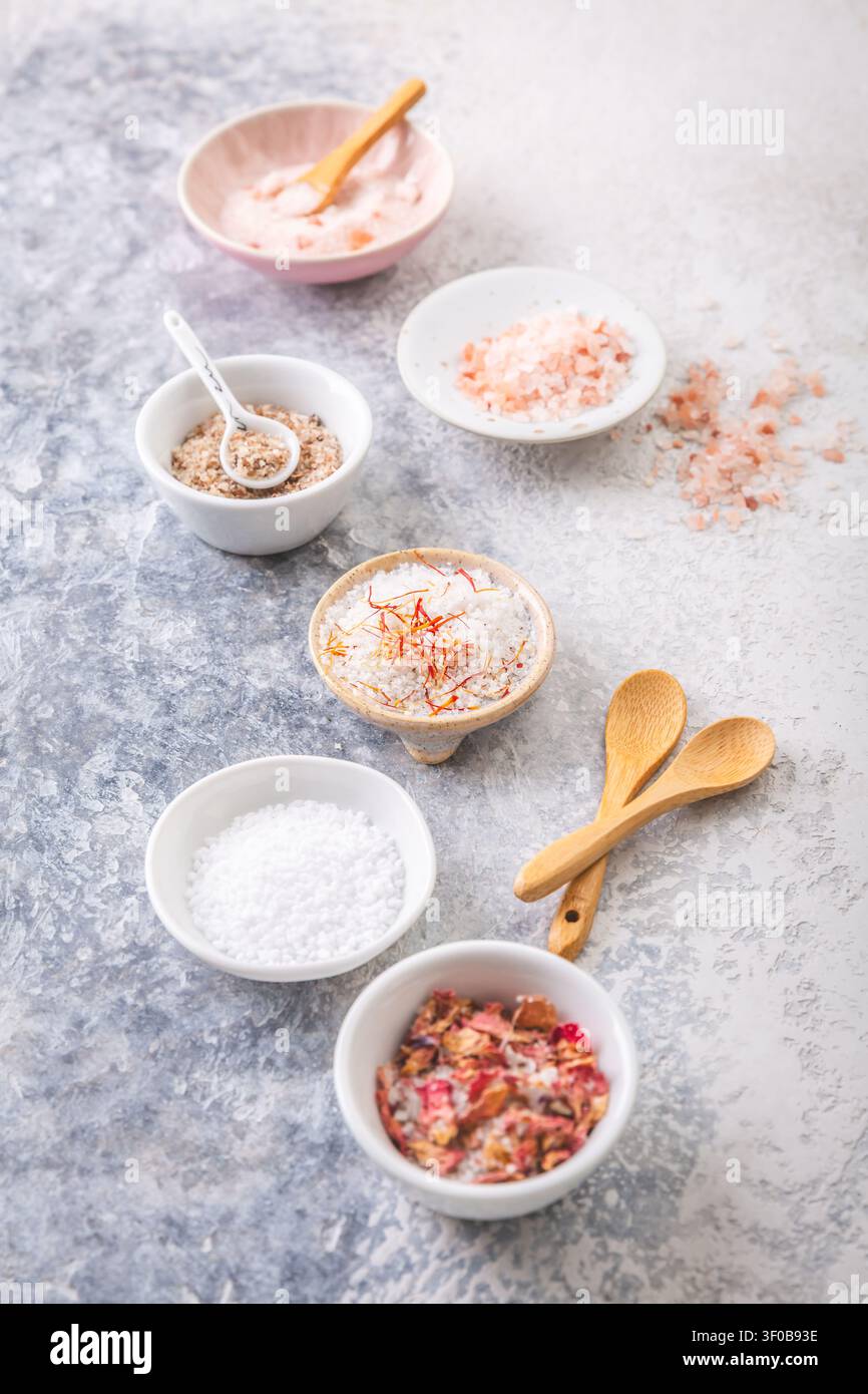 Assortiment de sels gastronomiques dans de petits bols, y compris l'Himalaya et les pétales de rose infusés Banque D'Images