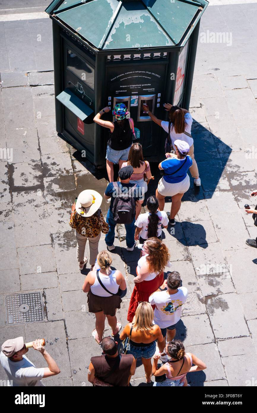 Touristes utilisant les stations de remplissage d'eau publiques gratuites par une journée très chaude à Rome, Italie Banque D'Images