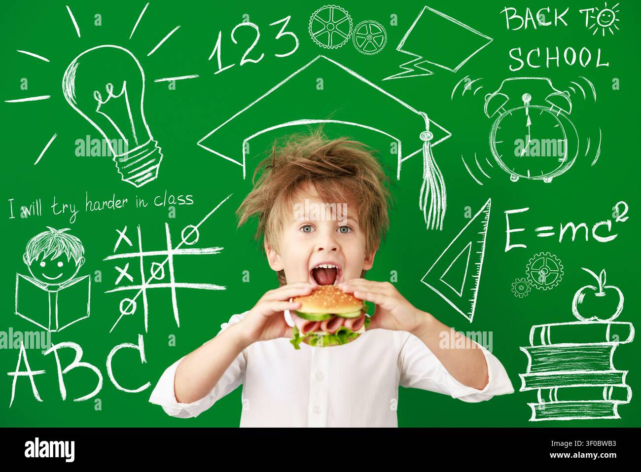 Enfant surpris en classe. Enfant drôle devant un fond de tableau vert. Concept de retour à l'école et d'éducation Banque D'Images