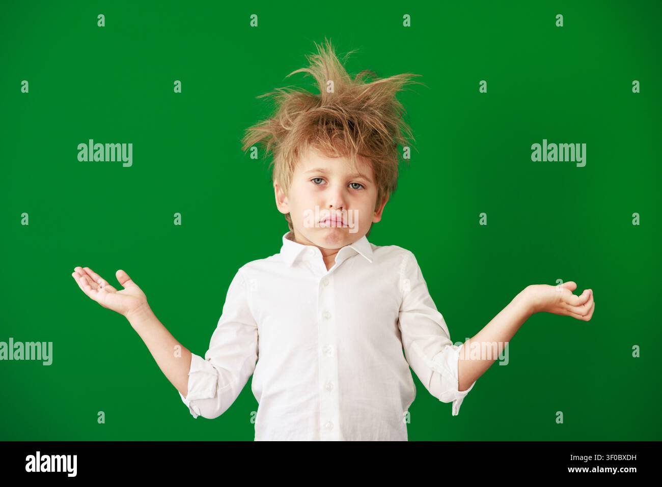 Enfant surpris en classe. Enfant drôle devant un fond de tableau vert. Concept de retour à l'école et d'éducation Banque D'Images