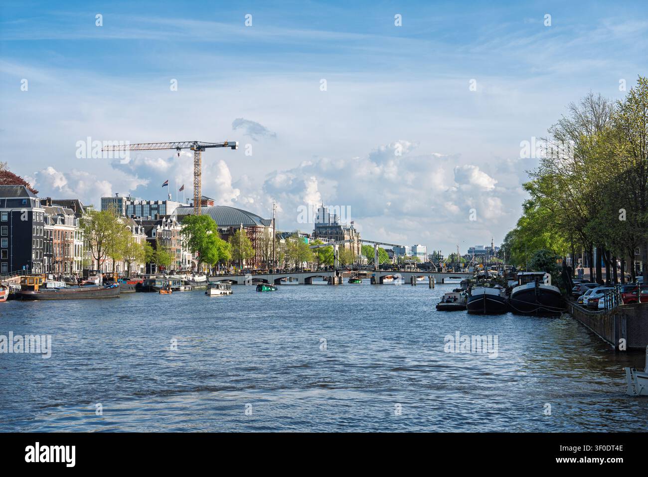 Vue pittoresque sur le fleuve Amstel avec une architecture historique et des bateaux à Amsterdam, Pays-Bas Banque D'Images