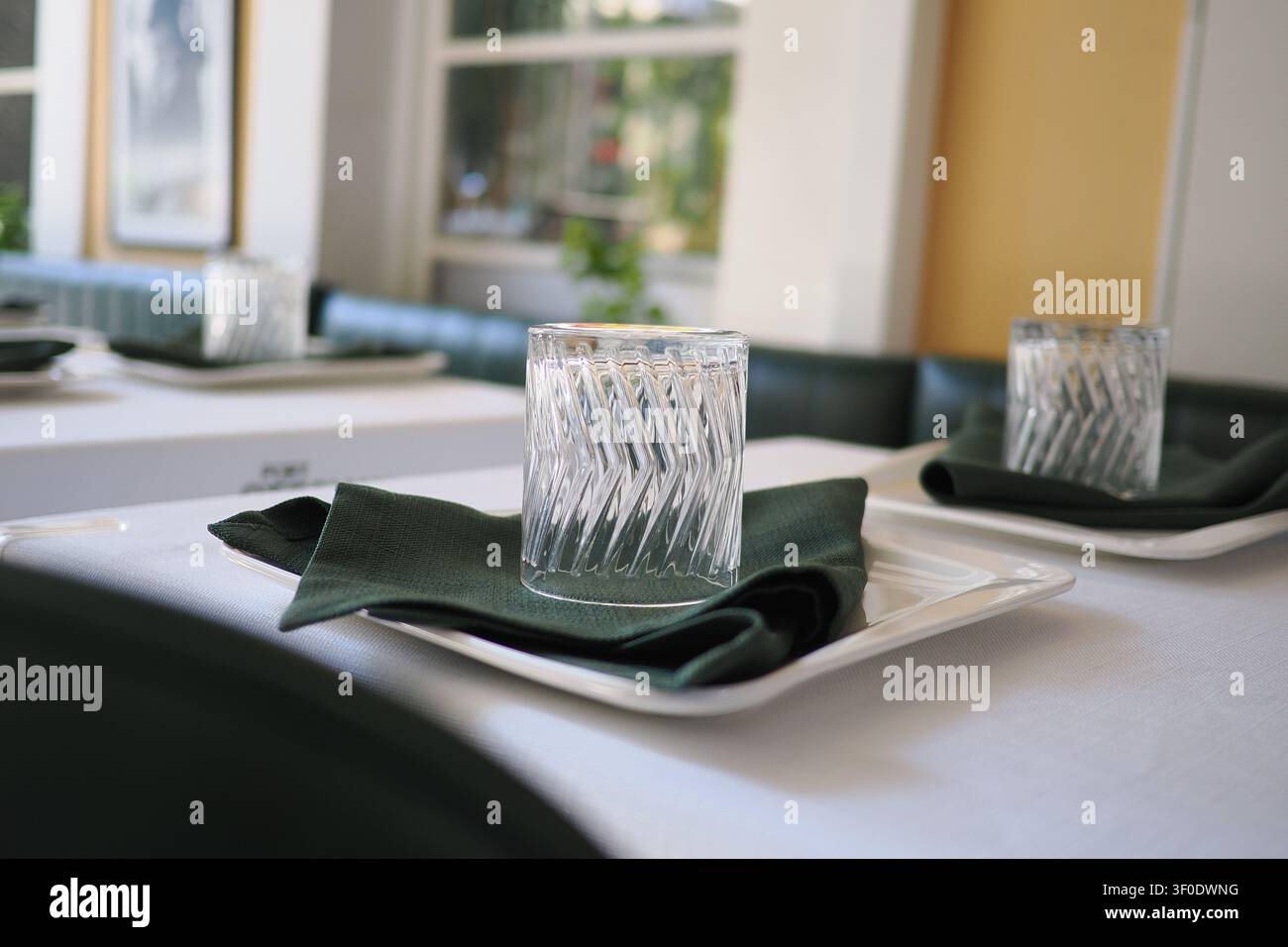 Élégante mise en table avec verrerie et serviettes à la lumière du soleil Banque D'Images