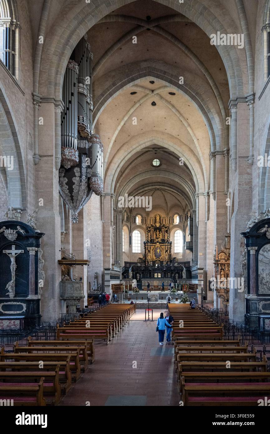Composition intérieure symétrique de la cathédrale de Trèves avec l'orgue à tuyaux suspendu et l'allée centrale menant vers l'autel. Banque D'Images