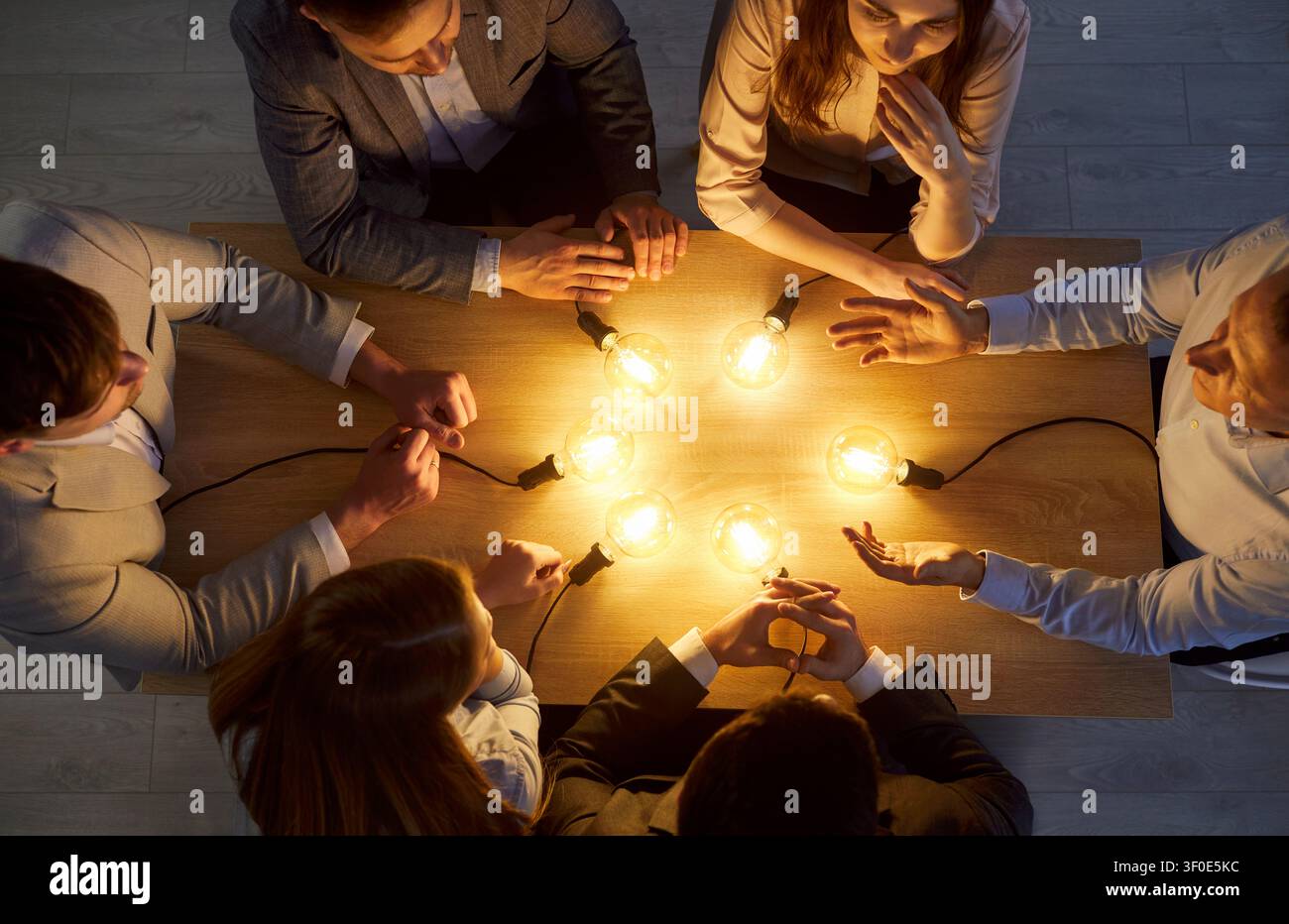 Équipe créative en brainstorming, groupe d'affaires prospère, inspiration de lampes à ampoule lumineuse Banque D'Images