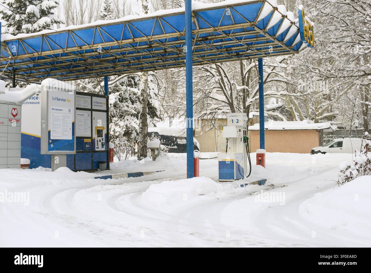 19 février 2025 - Ruse, Bulgarie : La neige recouvre une station-service en libre-service Petrol et un casier à colis Sameday Easybox pendant les chutes de neige hivernales. Banque D'Images