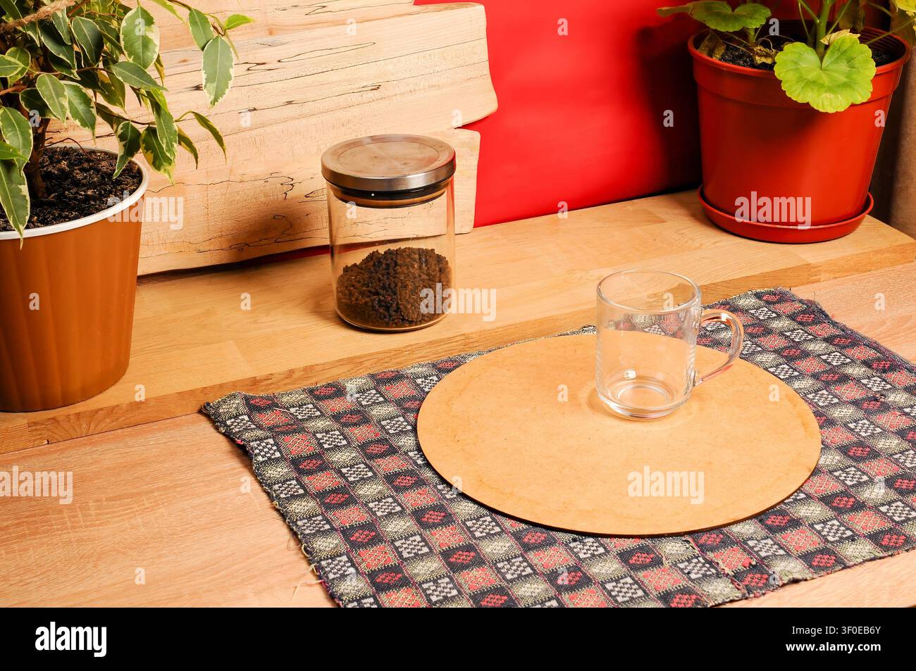 Une tasse en verre et un pot de marc de café sont posés sur une table en bois avec des plantes Banque D'Images