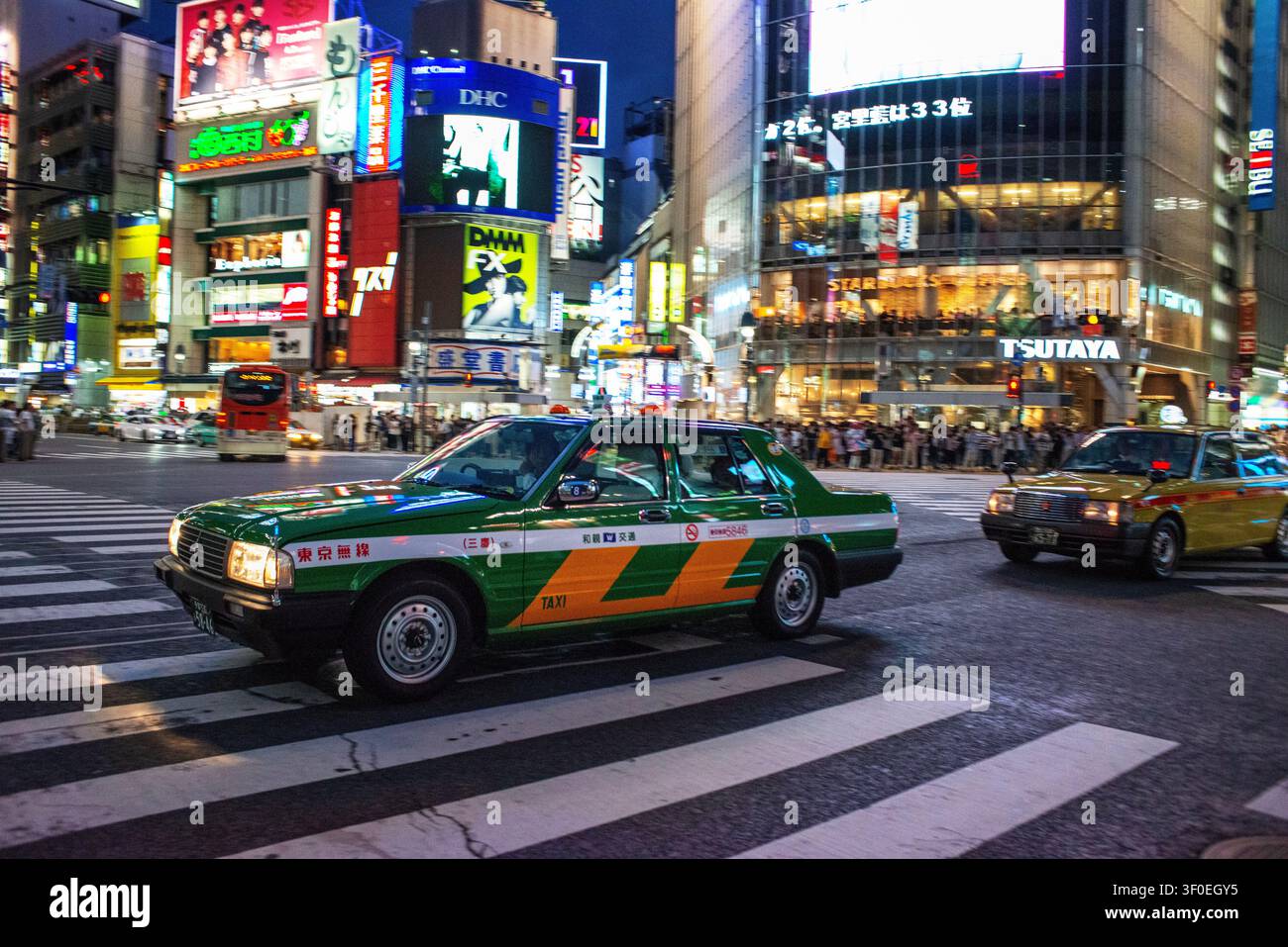 Taxi et vue nocturne du célèbre croisement de Shibuya à Shibuya, Tokyo, Japon. La photo capture l'atmosphère vibrante d'un Banque D'Images