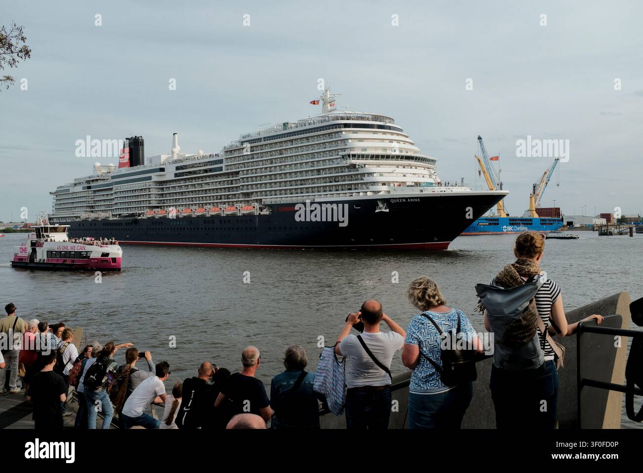 Les spectateurs admirent le navire de croisière Queen Anne alors qu'il quitte le port de Hambourg. Le navire de croisière passe devant la promenade de l'Elbe près de l'Elbphilh Banque D'Images