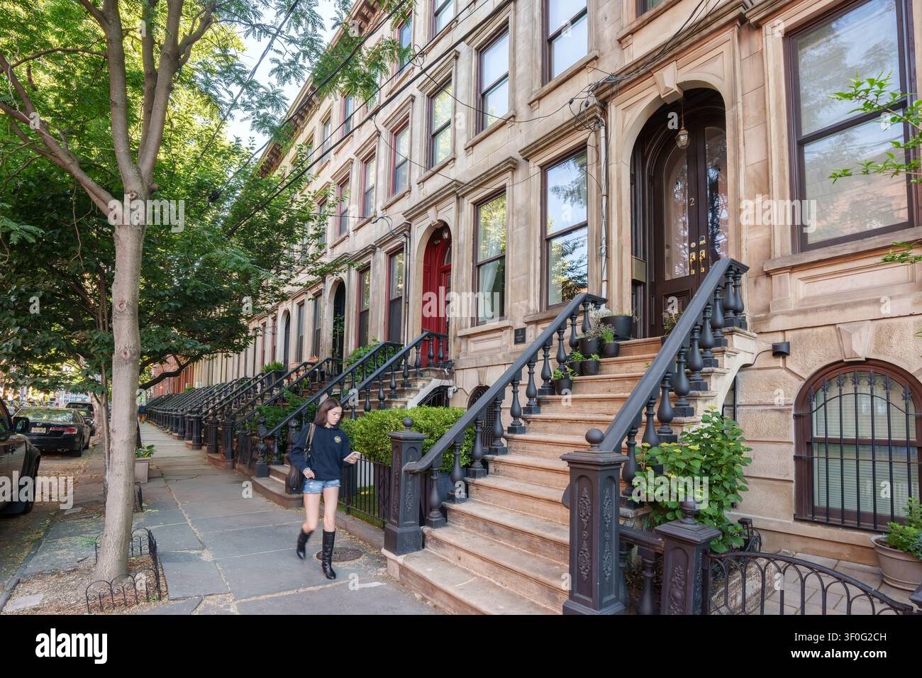 Jeune femme se promenant autour des maisons historiques et des anciens bâtiments résidentiels autour du parc Hamilton à Jersey City, New Jersey, États-Unis. Banque D'Images