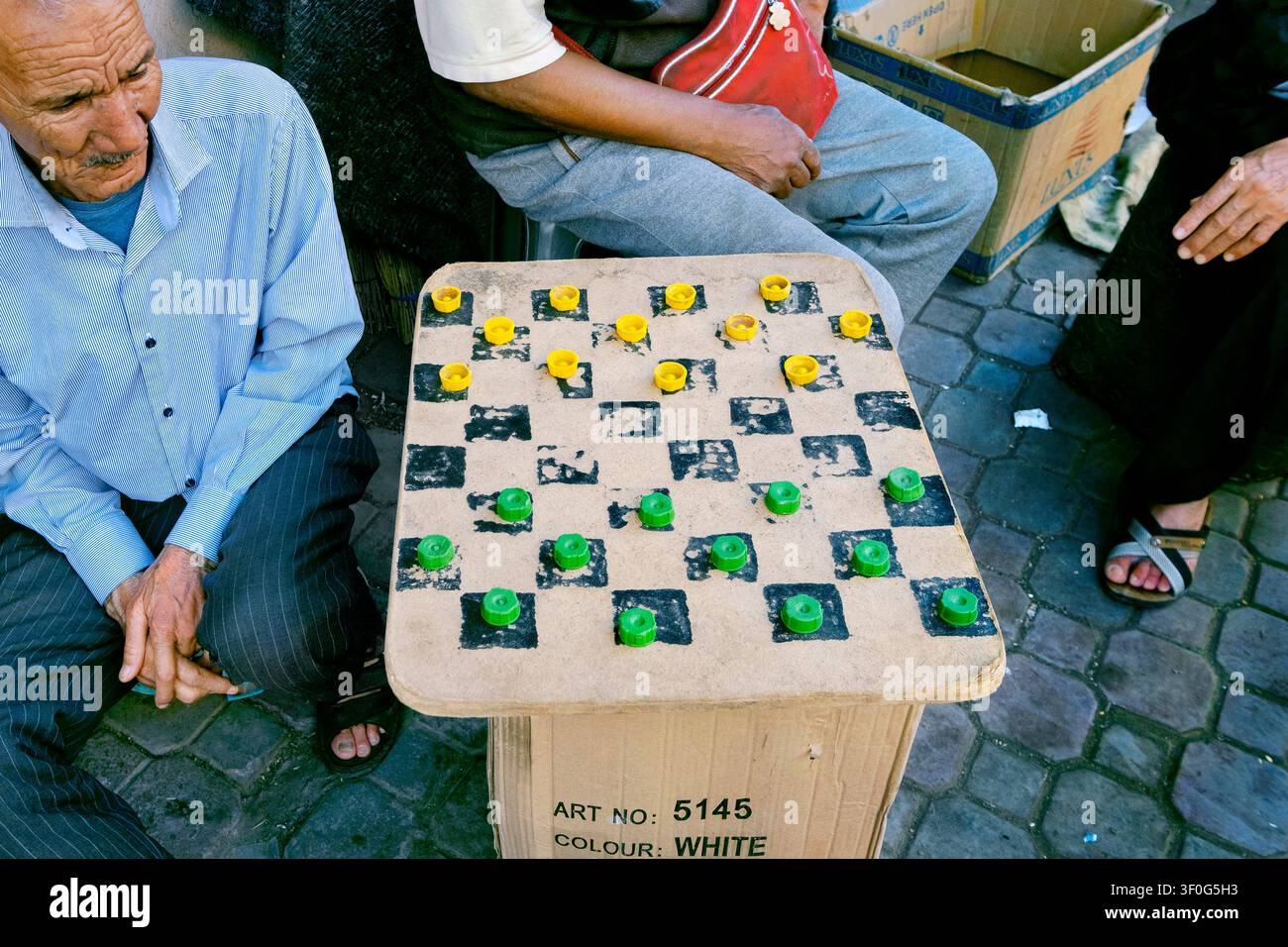 Jeu de dames avec des bouchons de bouteilles en plastique pour les pions, Médina, Marrakech, Maroc, Afrique du Nord Banque D'Images