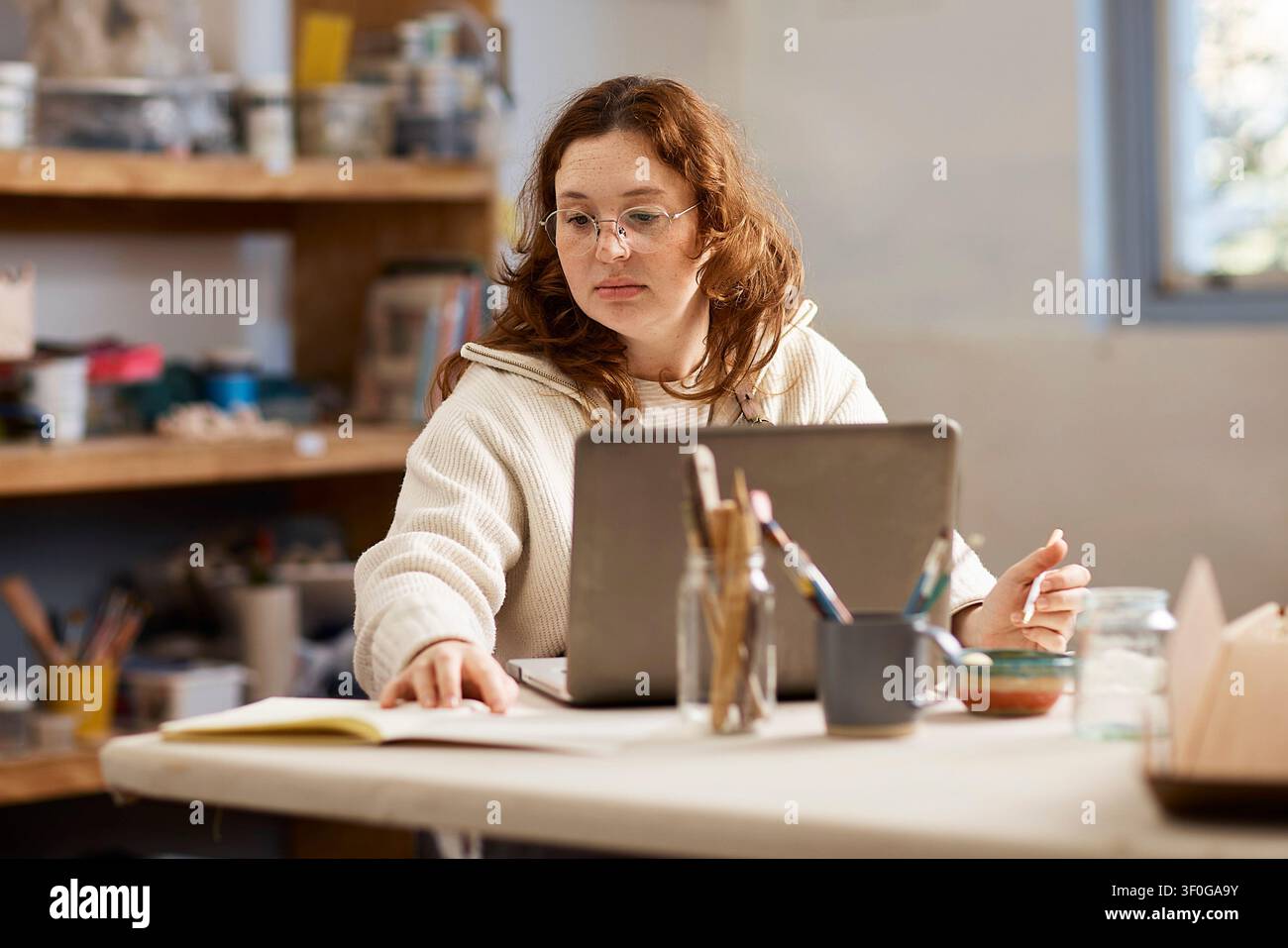 Propriétaire d'une petite entreprise d'atelier de poterie travaillant sur un ordinateur portable dans un studio de céramique créatif Banque D'Images