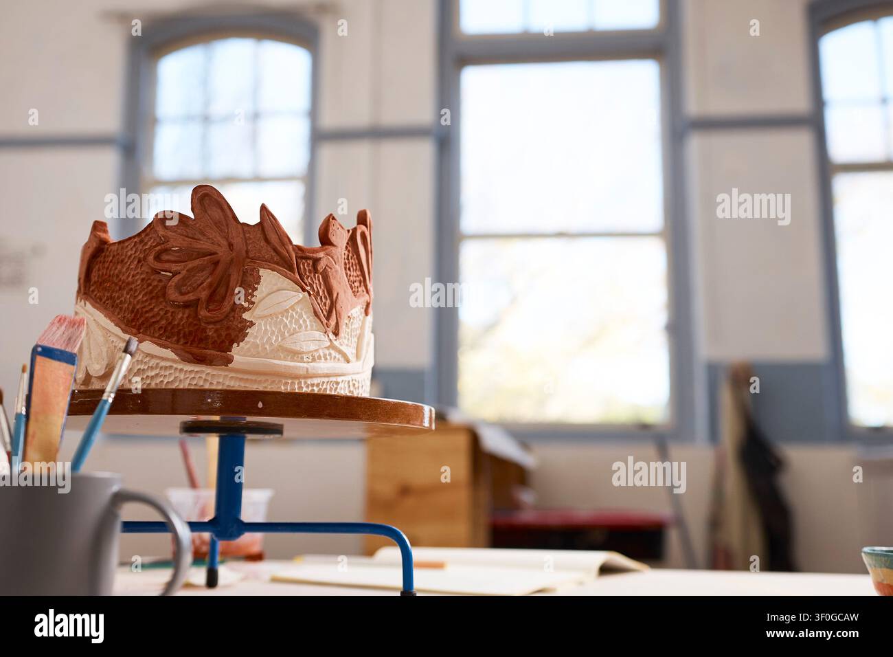 Sculpture de couronne en argile artisanale sur un tour de potier dans un atelier de poterie lumineux par un artiste créatif Banque D'Images