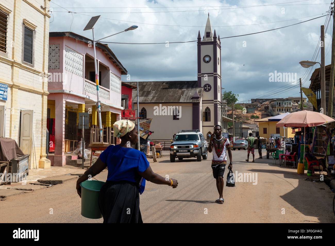 Scène de rue avec tour d'église et piétons, Elmina, Ghana Banque D'Images
