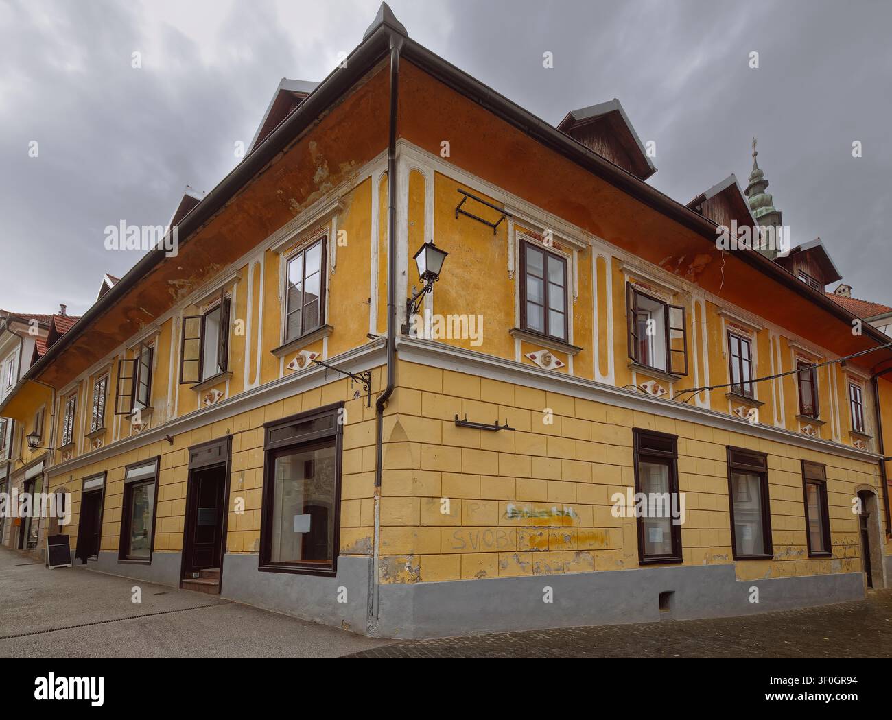 142 Maison d'angle ornée de têtes humaines dépassant de médaillons rhombiques sous les fenêtres, Mestni trg et Blazeva ulica, Skofja Loka-Slovénie Banque D'Images