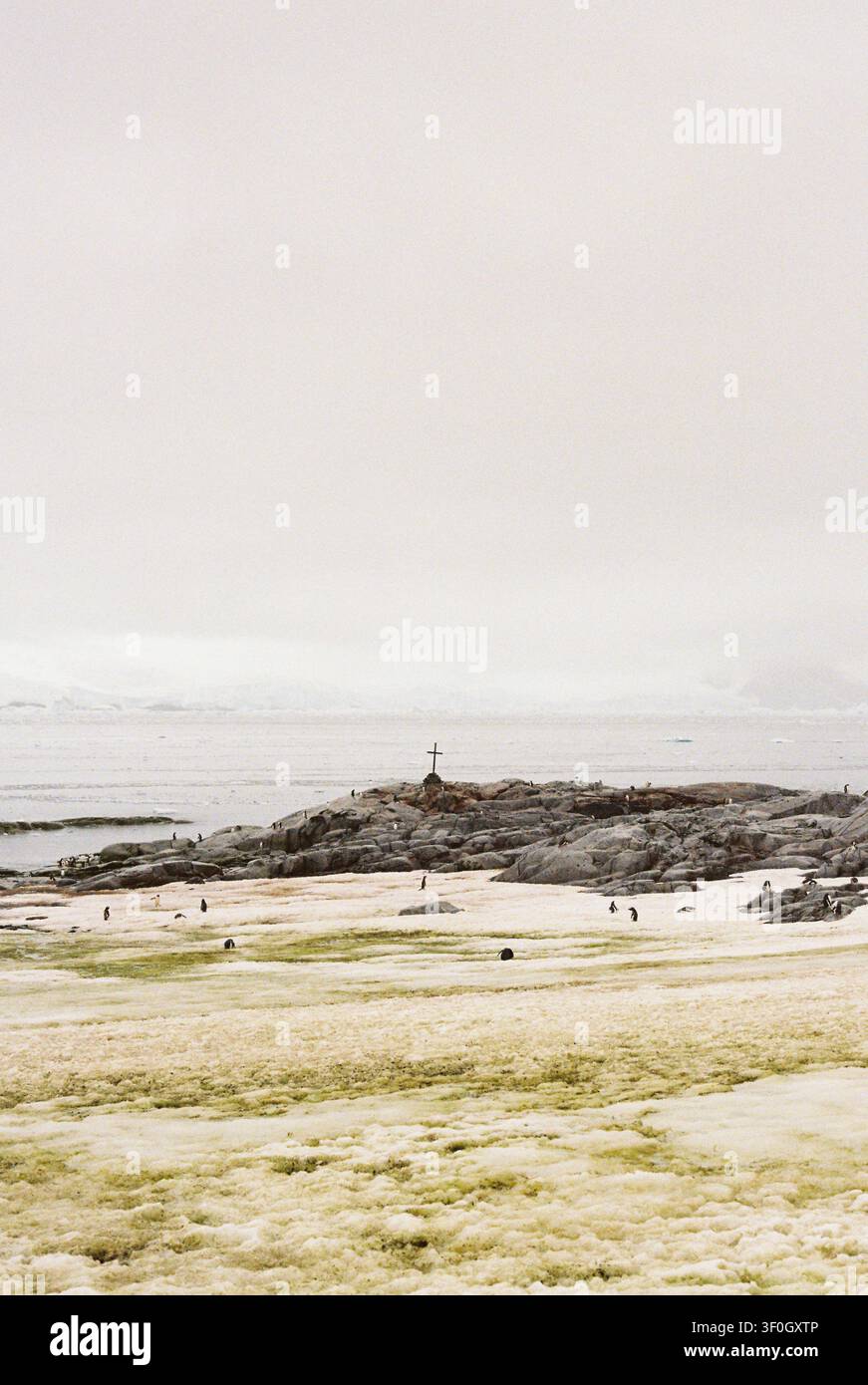 Calvaire historique en pierre et croix commémorative sur une colline éloignée surplombant l'océan antarctique, sur film. Banque D'Images