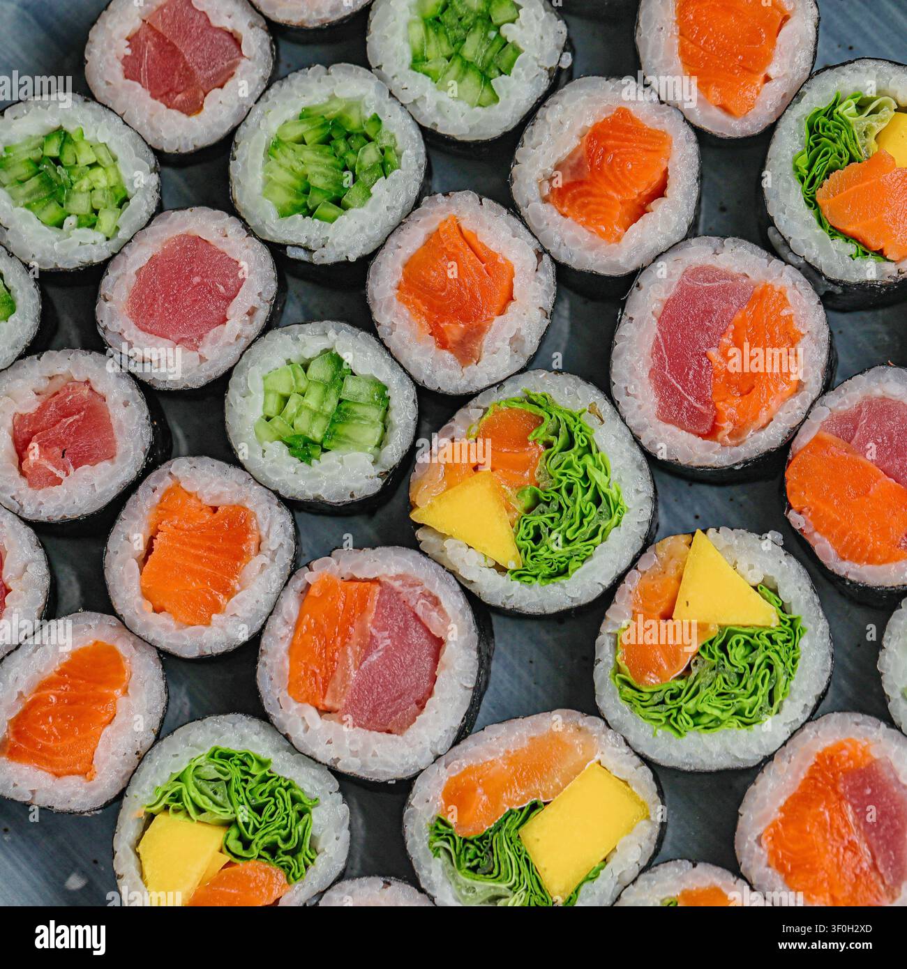 Un plateau présentant une sélection de rouleaux de sushi arborant différentes garnitures et remplissages. Banque D'Images