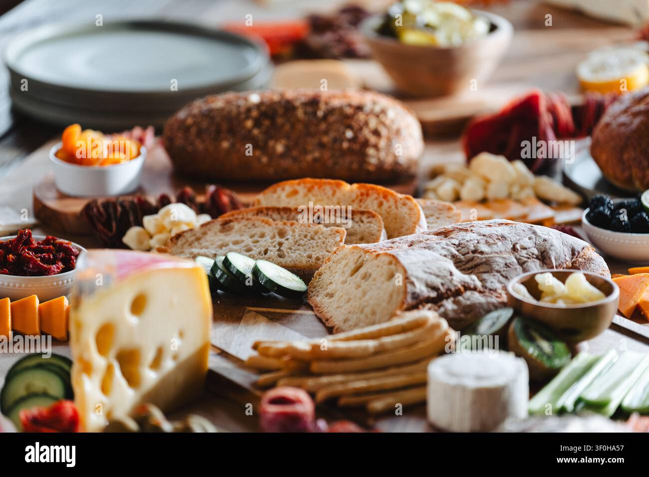 Planche de charcuterie rustique avec pain au levain et fromages variés Banque D'Images