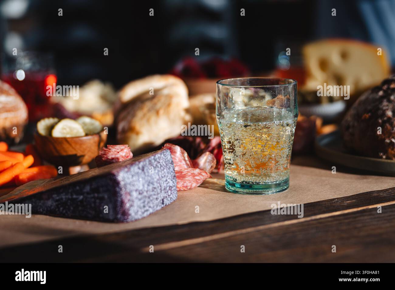 Planche de charcuterie gourmet avec du vin et des amuse-gueules sur une table en bois Banque D'Images