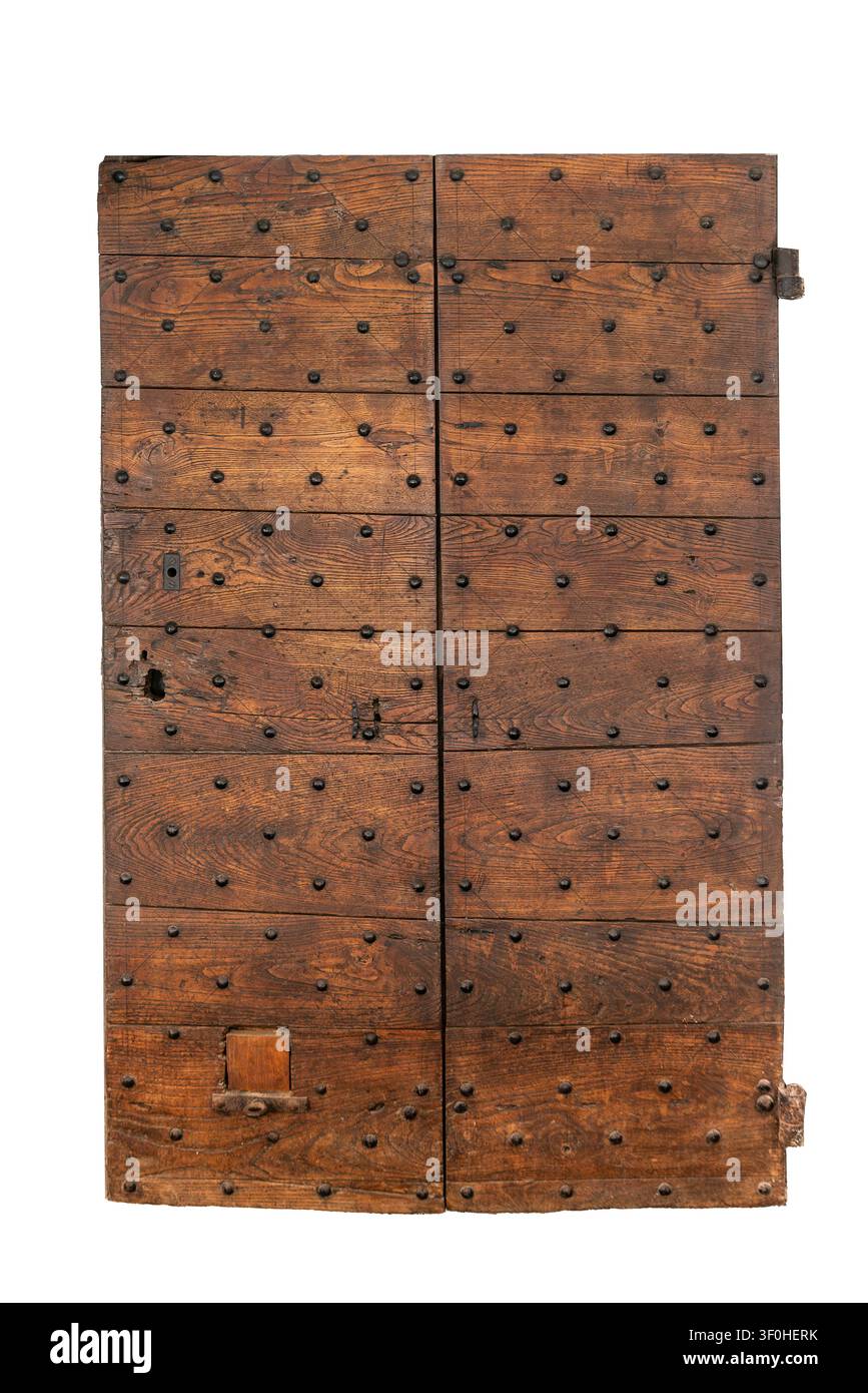 Vue avant d'une porte en bois antique usée à deux battants, renforcée de clous en fer décoratifs et de ferronnerie historique, datant du Banque D'Images