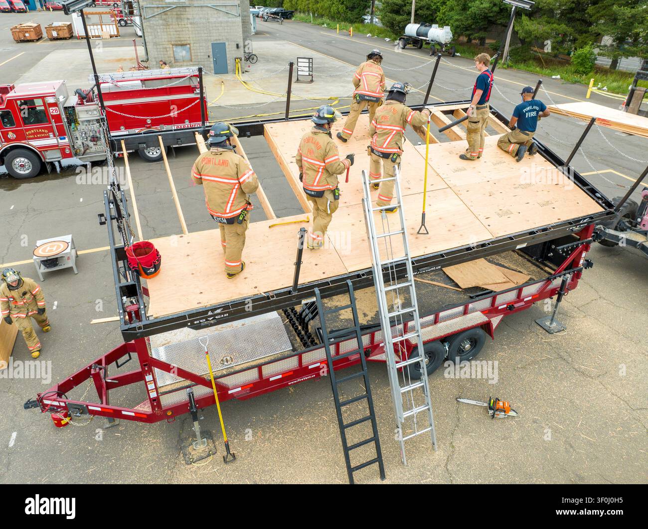 Les recrues pompiers en période d’essai acquièrent des compétences en lutte contre les incendies et en sauvetage auprès de pompiers chevronnés. Banque D'Images