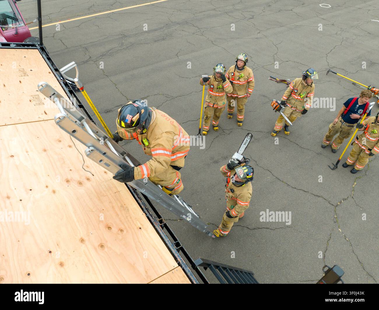 Les recrues pompiers en période d’essai acquièrent des compétences en lutte contre les incendies et en sauvetage auprès de pompiers chevronnés. Banque D'Images