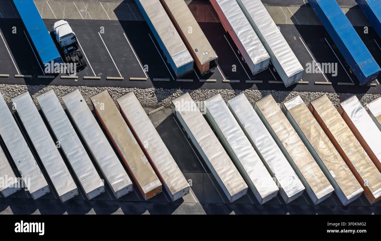 Camions et semi-remorques garés dans un dépôt logistique, montrant le transport et l'expédition Banque D'Images