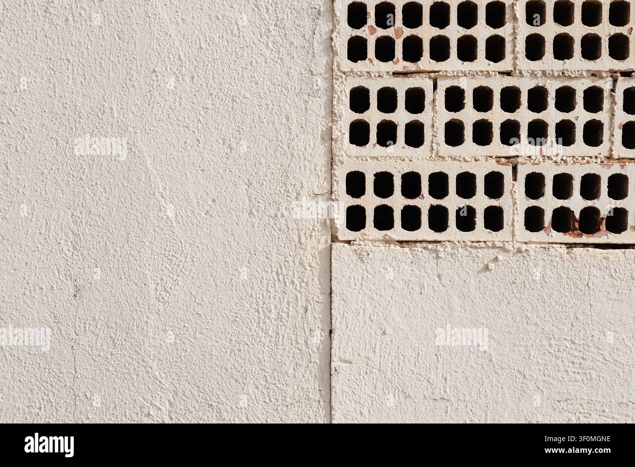 Mur peint en blanc avec briques perforées apparentes Banque D'Images