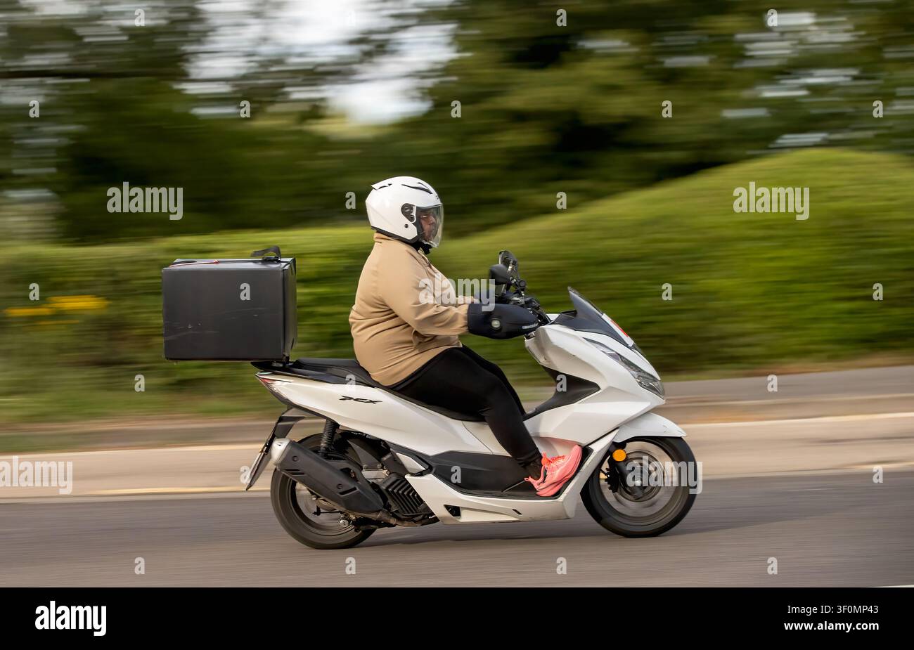 Milton Keynes, Bucks, UK - 4 juillet 2026 : Homme conduisant une scooter motorisé Honda ww 125 ap de 2024 sur une route britannique Banque D'Images