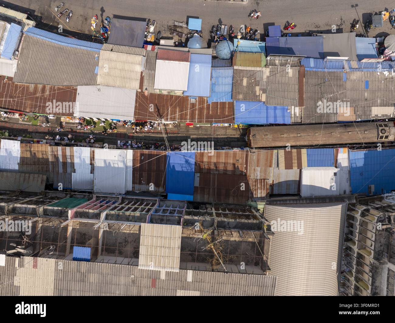 Vue aérienne du marché ferroviaire de Maeklong avec des auvents colorés et des toits en métal bordant les voies ferrées à Mae Klong, Samut Songkhram, Thaïlande. Banque D'Images