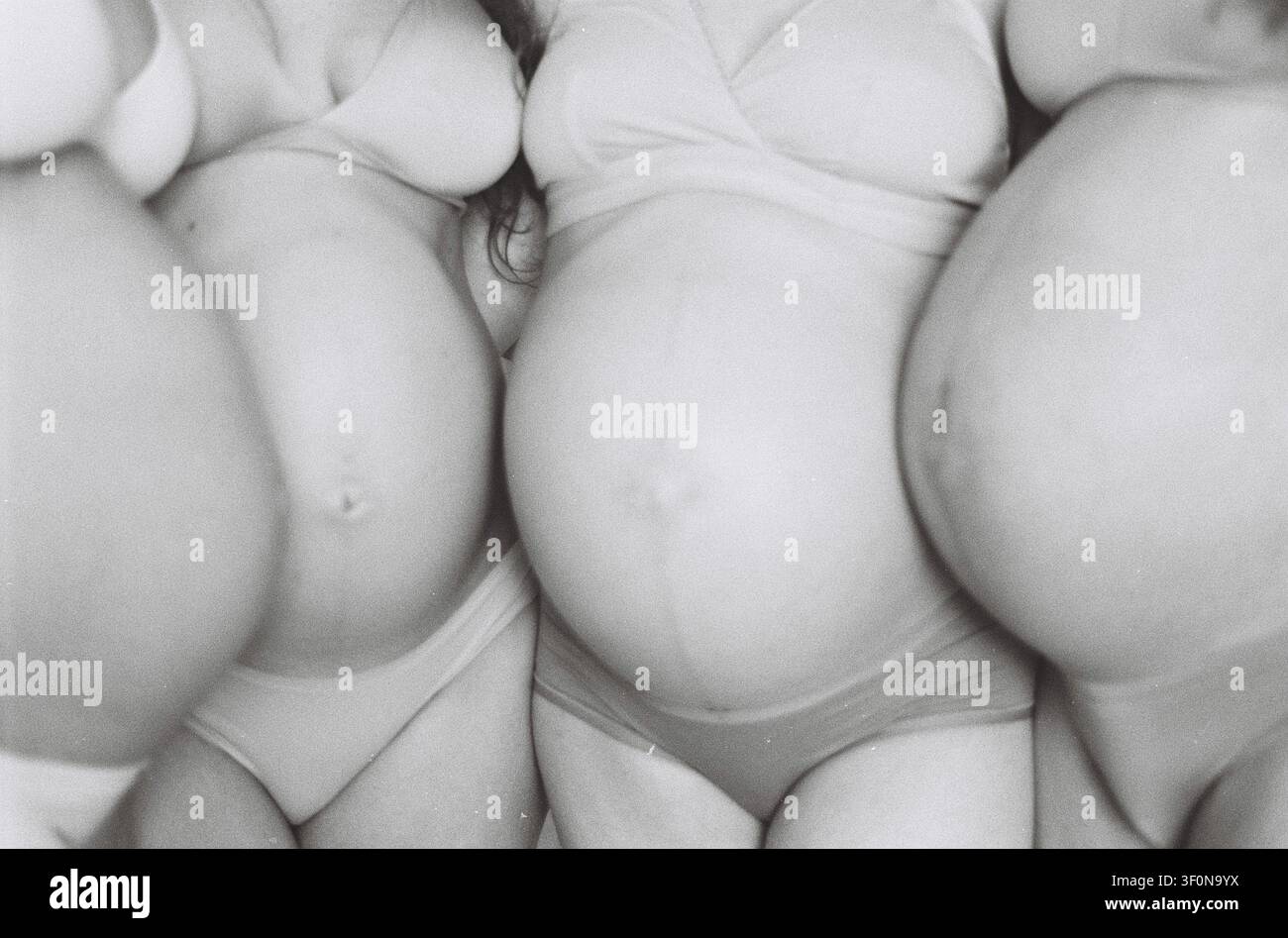 Groupe de femmes enceintes photo analogique avec le ventre exposé, concept de maternité et de fertilité, noir et blanc Banque D'Images