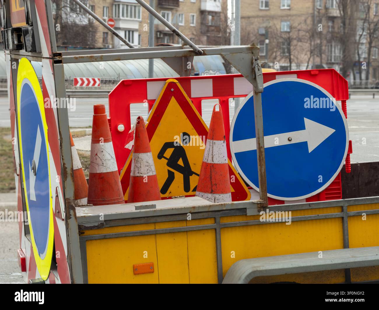 Marqueurs d'avertissement routier et barrières métalliques fixées sur un véhicule, créant une zone protégée qui communique les réparations essentielles des infrastructures et ca Banque D'Images