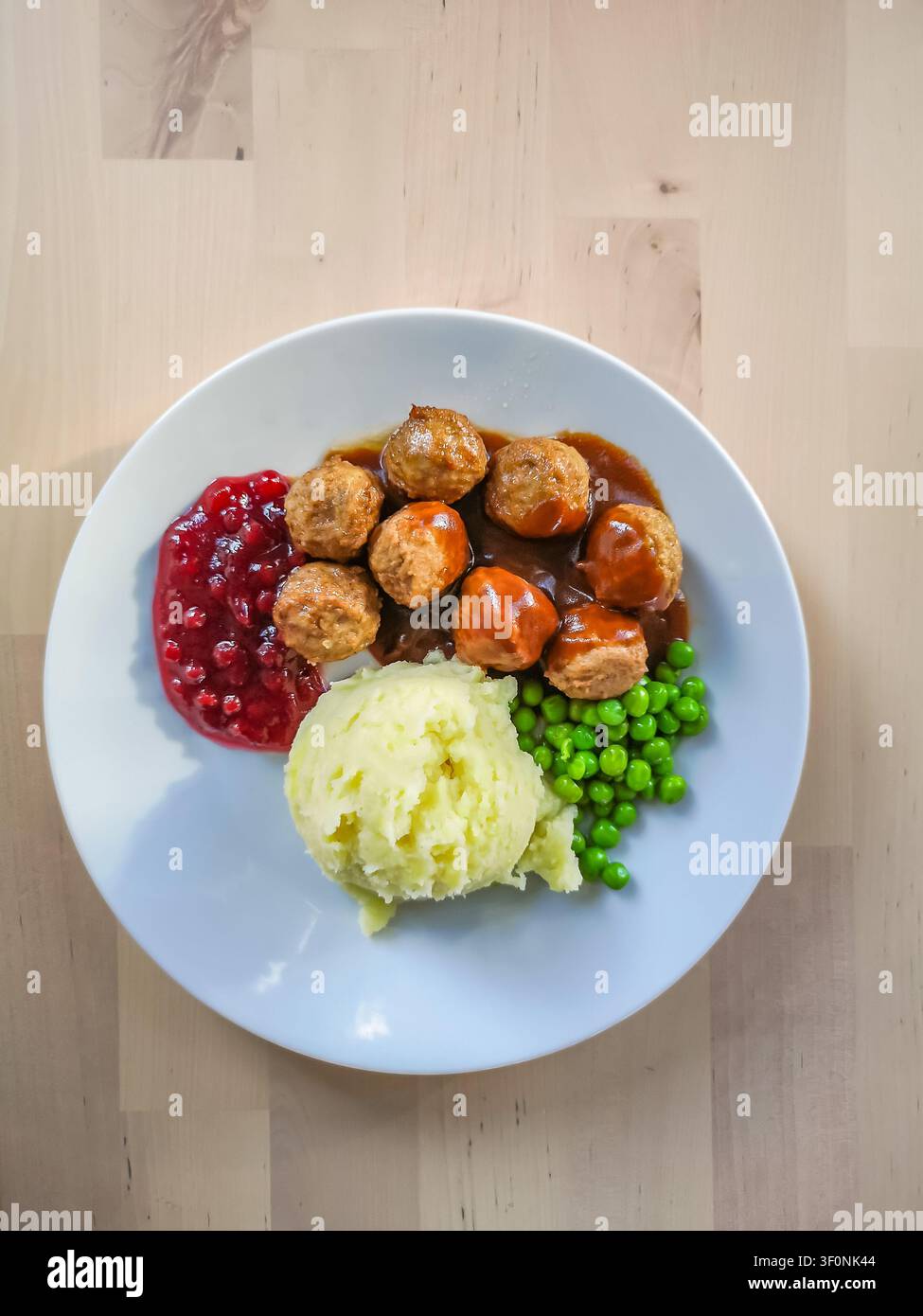Plat suédois traditionnel – boulettes de viande avec sauce aux airelles, purée de pommes de terre et petits pois verts Banque D'Images