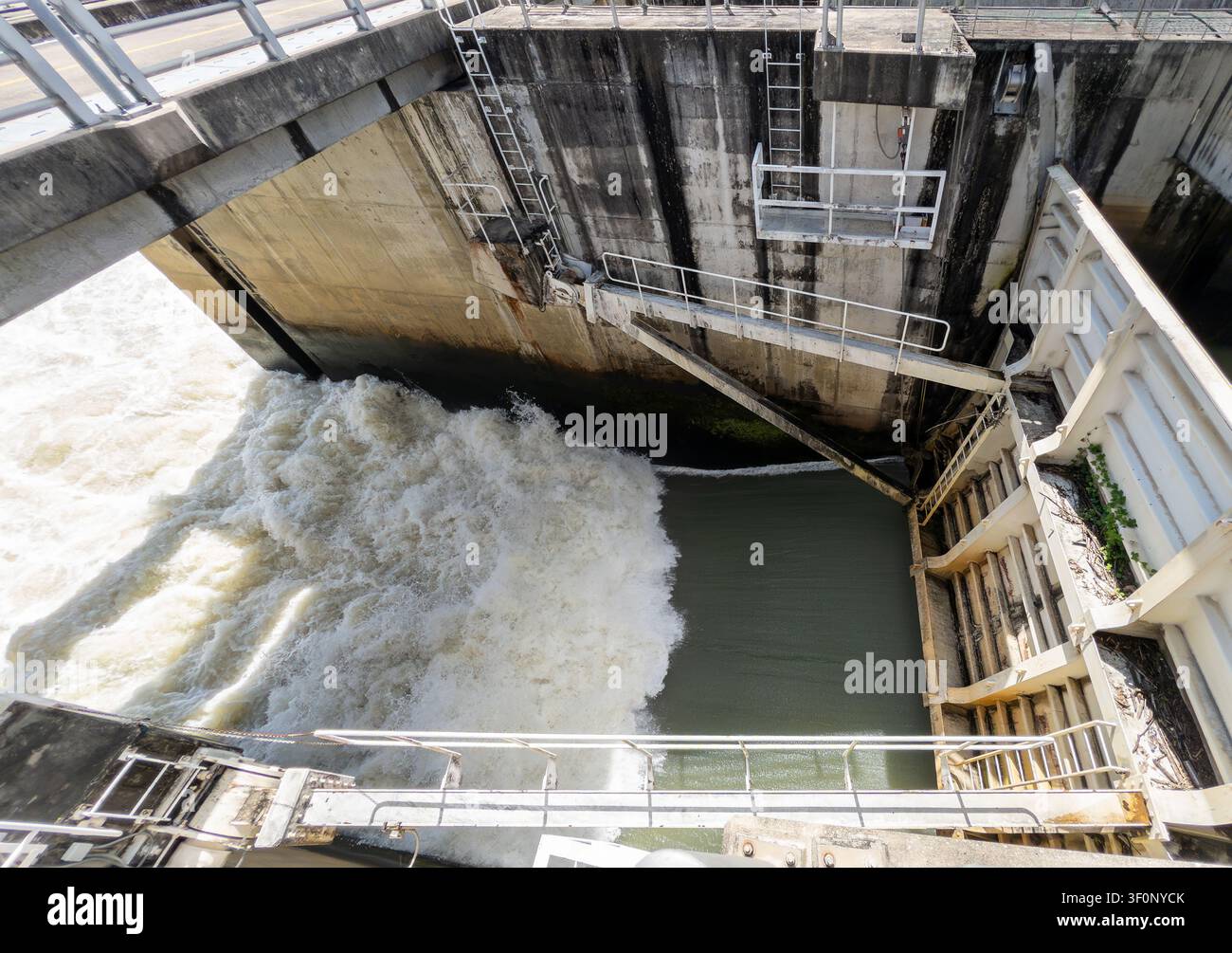 Vue en hauteur d'un écoulement de barrage libérant l'eau à travers des vannes hydrauliques. Infrastructure de gestion industrielle de l'eau pour le contrôle des inondations, l'irrigation Banque D'Images