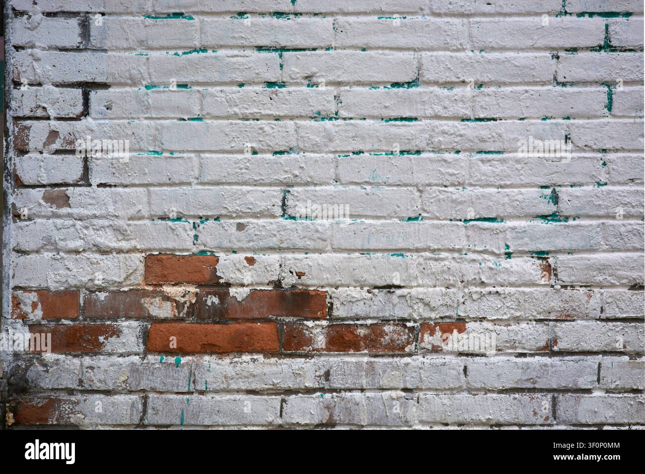 Texture de vieux mur de briques avec peinture blanche écaillée et briques rouges apparentes Banque D'Images