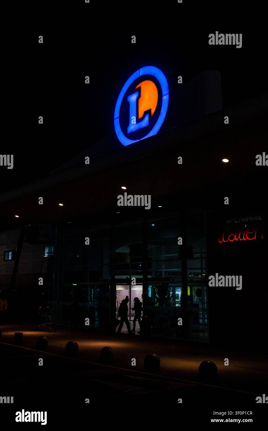 Vue extérieure nocturne de l'enseigne E.Leclerc illuminée sur la façade d'un supermarché et d'un centre commercial dans la région de Dinan, Dinan, Bretagne, France le Banque D'Images