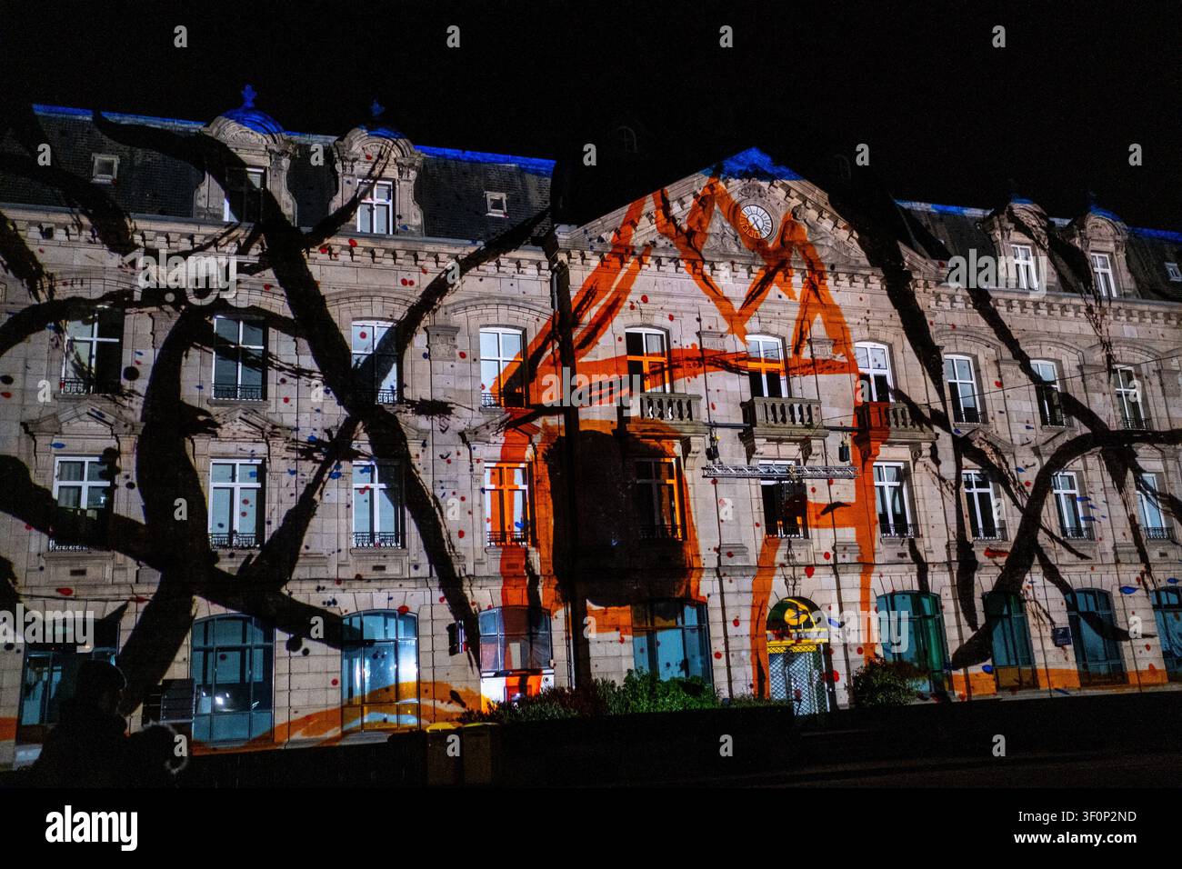 Vue nocturne d'une façade en pierre historique recouverte d'une projection sonore et lumineuse de Noël près de la Place de la Poste dans le centre-ville de Saint-Brieuc, Coté Banque D'Images
