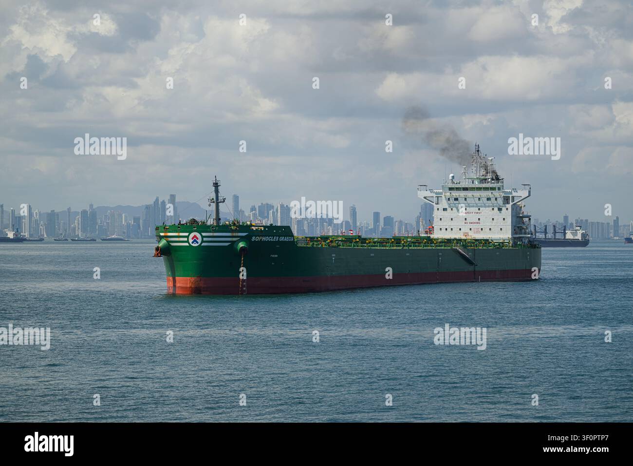 Le navire cargo Cargo Ship Sophocles Graecia au large des côtes du Panama près de l'entrée du canal de Panama avec la skyline de la ville de Panama en arrière-plan Banque D'Images