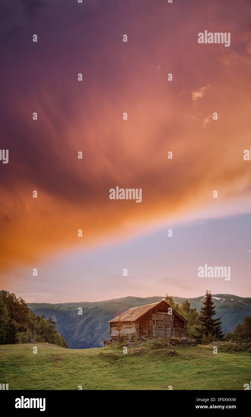 Ancienne cabane en bois surplombant le fjord d'Aurland au coucher du soleil en Norvège. Banque D'Images