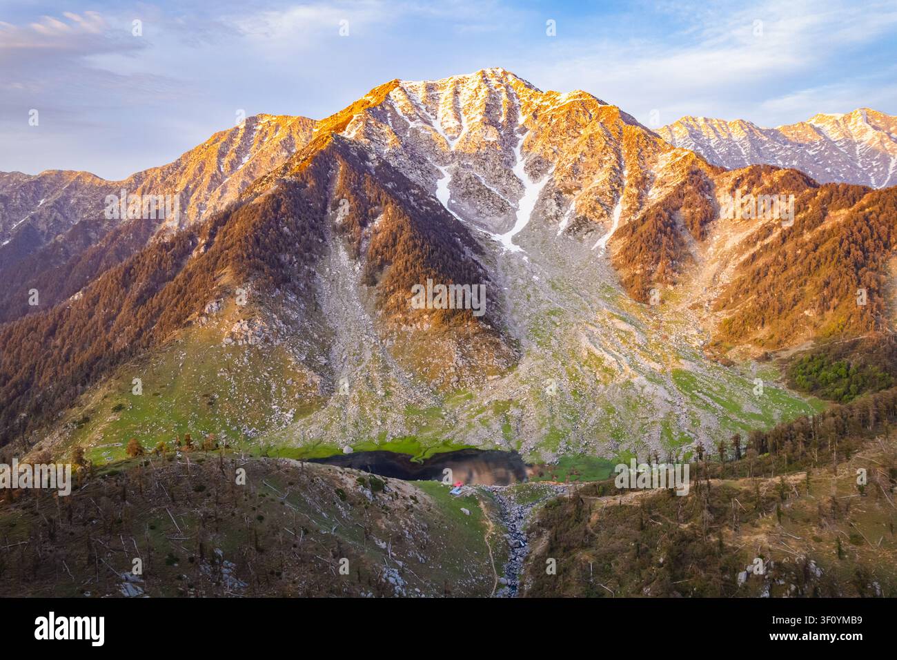 Une vue aérienne du paisible lac Kareri entouré de pics montagneux abrupts de l'Himalaya dans l'Himachal Pradesh. Banque D'Images
