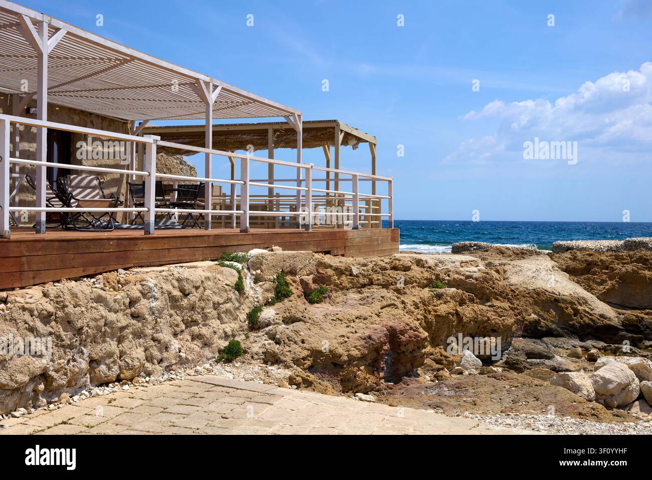 Restaurant en terrasse au bord de la mer avec vue sur la côte rocheuse à Marzamemi, Sicile, Italie Banque D'Images