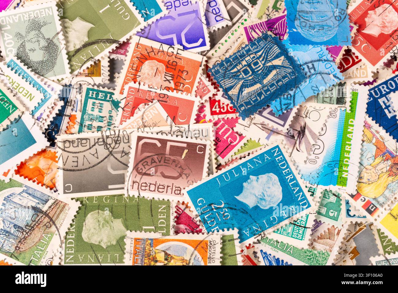 De nombreuses timbres postaux sont étalés sur une table. Ils viennent de différentes nations et présentent divers designs et couleurs. Les timbres montrent leur f unique Banque D'Images