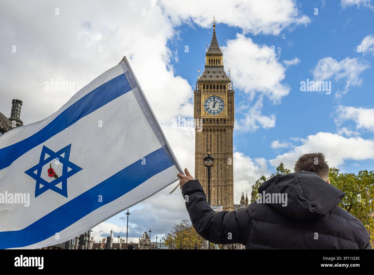 Person tenant un drapeau israélien près de Big Ben à Londres Banque D'Images