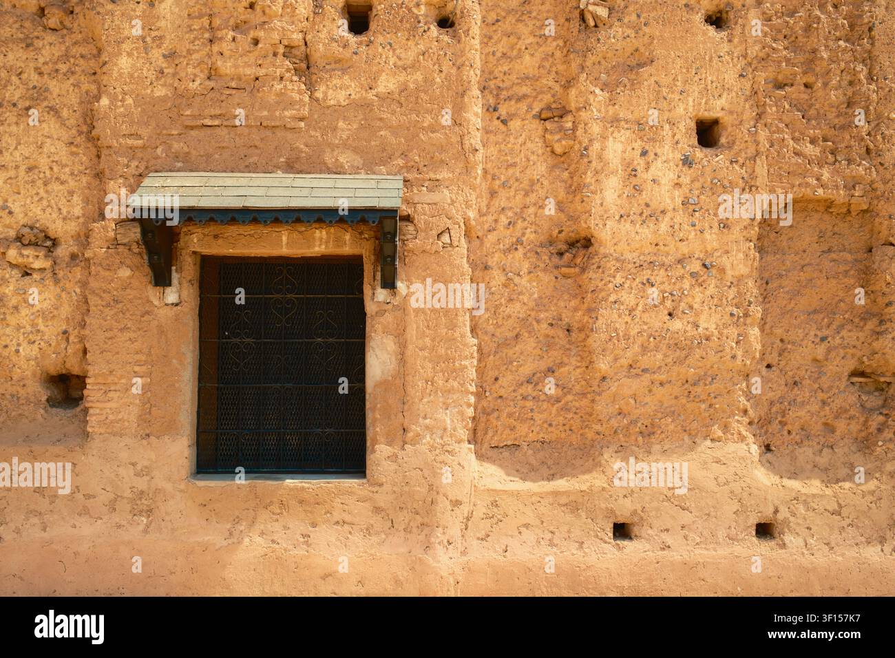 Petite fenêtre dans un mur marocain en terre Banque D'Images