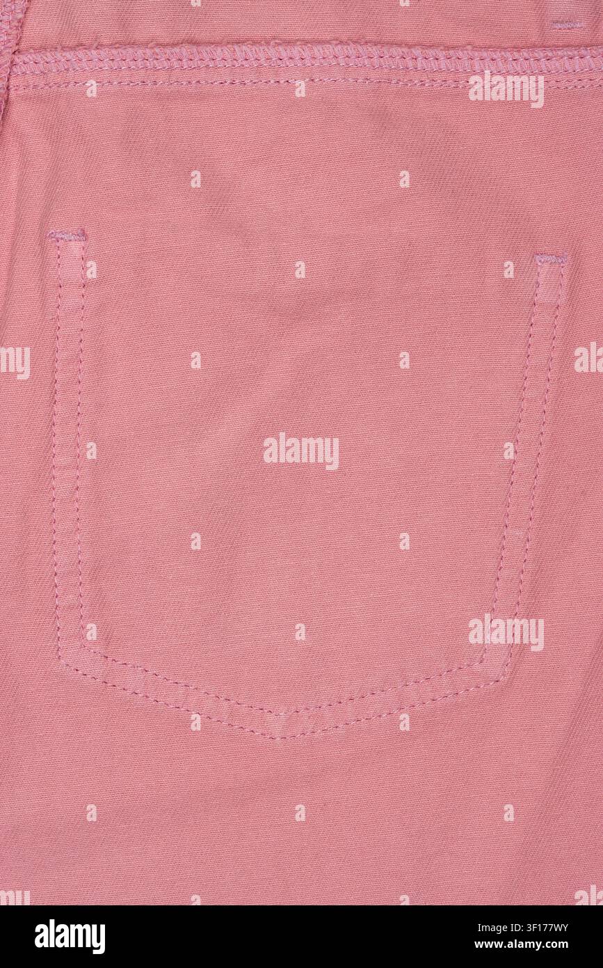 gros plan sur un tissu denim rose montrant la poche arrière avec des coutures soignées et une trame texturée. Ton pastel doux, un éclairage uniforme met en valeur les détails du matériau Banque D'Images