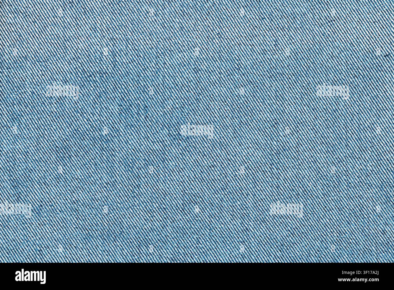 Grossissement d'un tissu en denim bleu montrant la texture de tissage en diagonale. Un éclairage naturel doux met en valeur les détails des fils. Idéal pour la mode, les textiles, backgr Banque D'Images