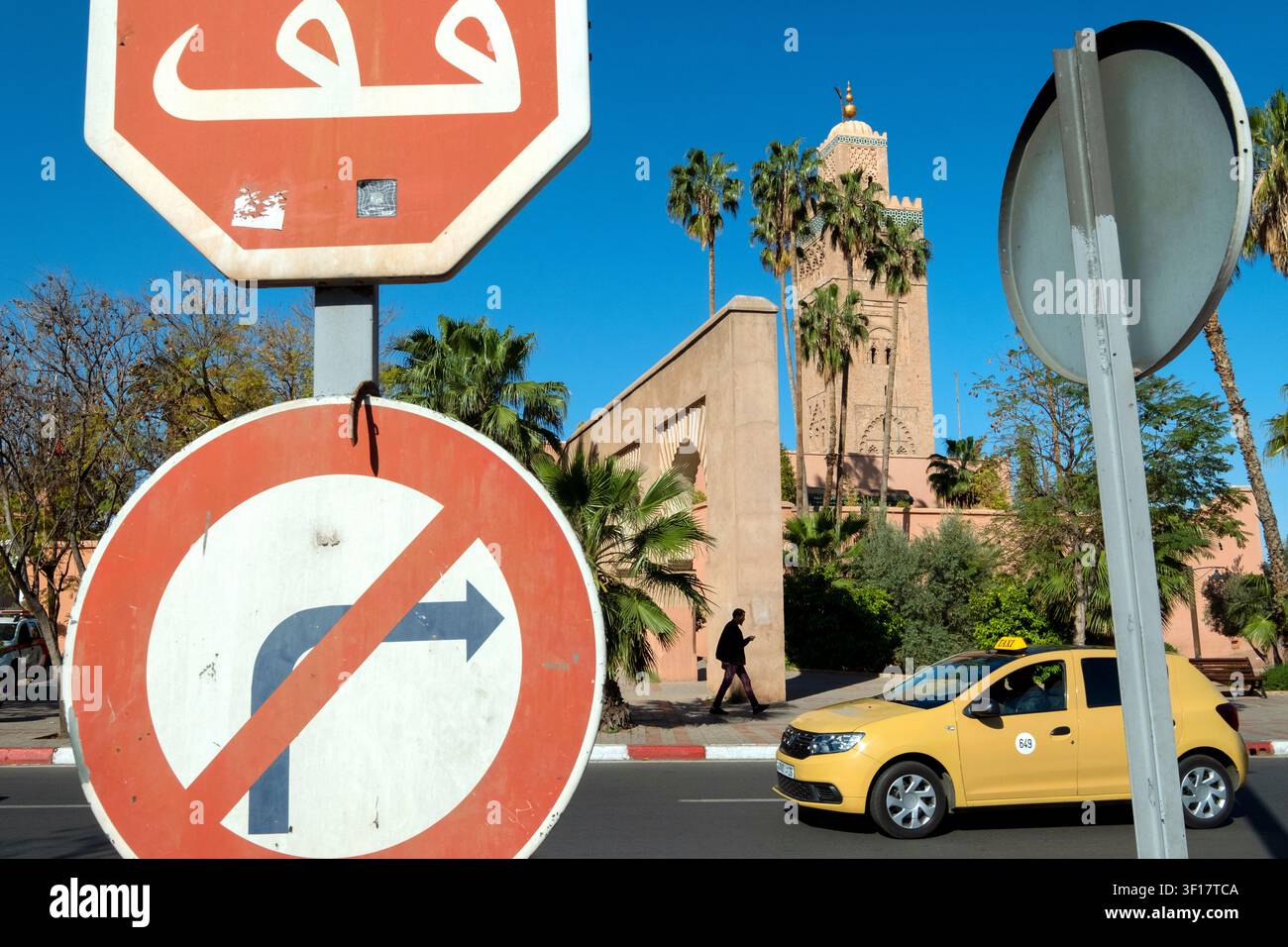 Panneaux de signalisation, un panneau d'arrêt et un panneau interdisant de tourner à droite, un taxi et le minaret de la mosquée Koutoubia, Marrakech, Maroc, Afrique du Nord Banque D'Images